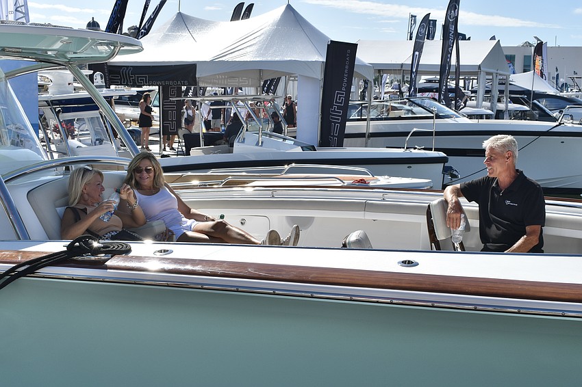 Stella Barone and Dana Gliniecki test a boat's relaxation factor as they talk with James Engelder of Cortez Cove Yacht Sales.
