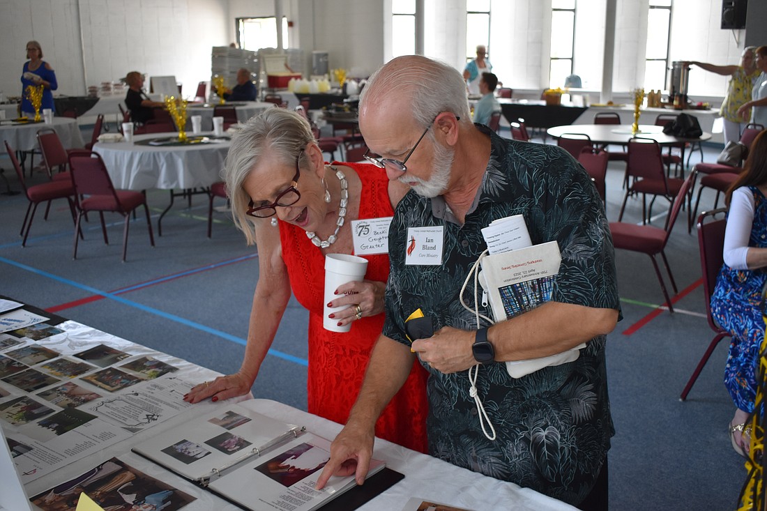 Becki Creighton and Ian Bland look over photos from the church's past.