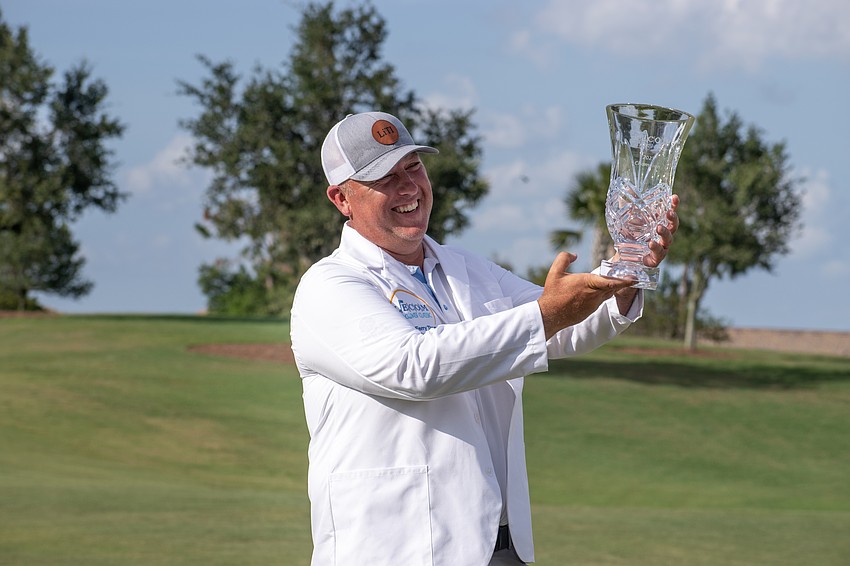 Scott Gutschewski holds up the 2023 LECOM Suncoast Classic trophy.