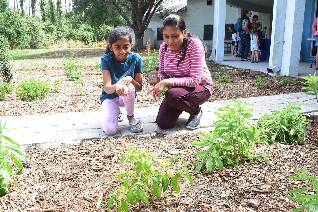 Bradenton's Aarna Patel, who is 9, looks at the different plants in the sensory garden with her mother, Rita Patel.