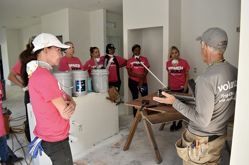 The flooring crew is given instructions and knee pads before the work begins.