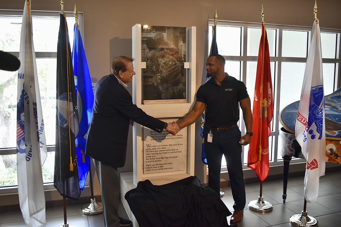 Ringling College President Larry Thompson and Veterans Club president Marcus Adkins unveil the monument.