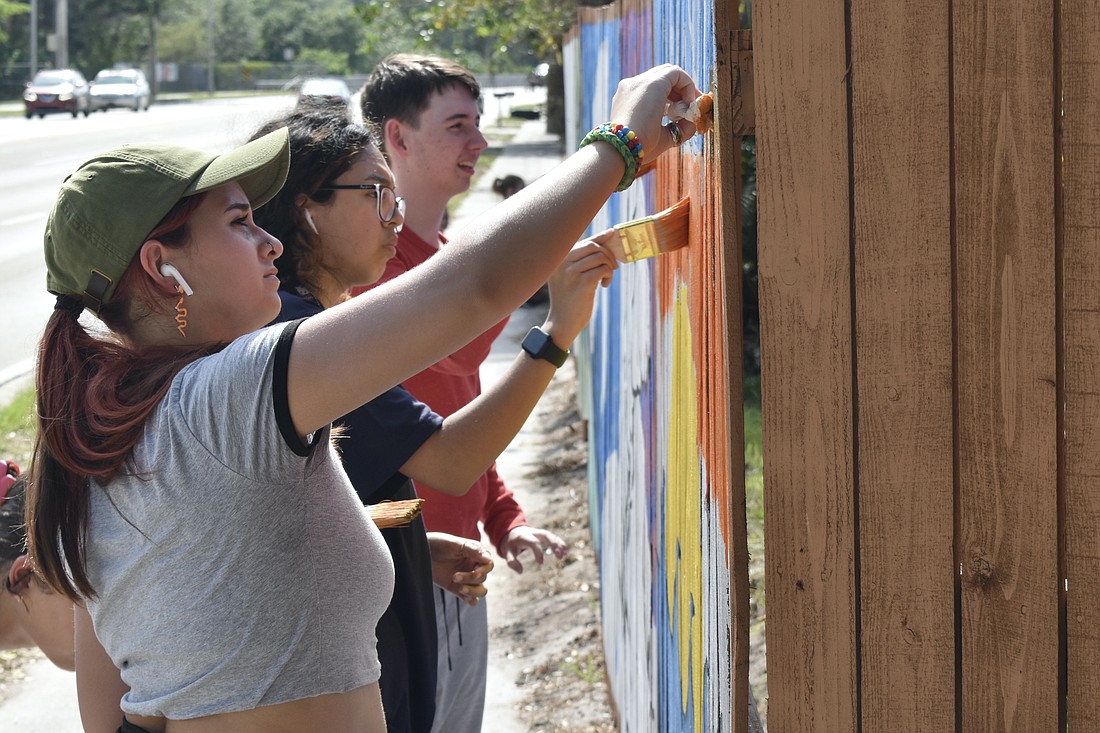11th grader Evanah Torres, 10th grader Izzy Martinez, and 11th grader Paul Cloutier work on Torres' section of the mural.