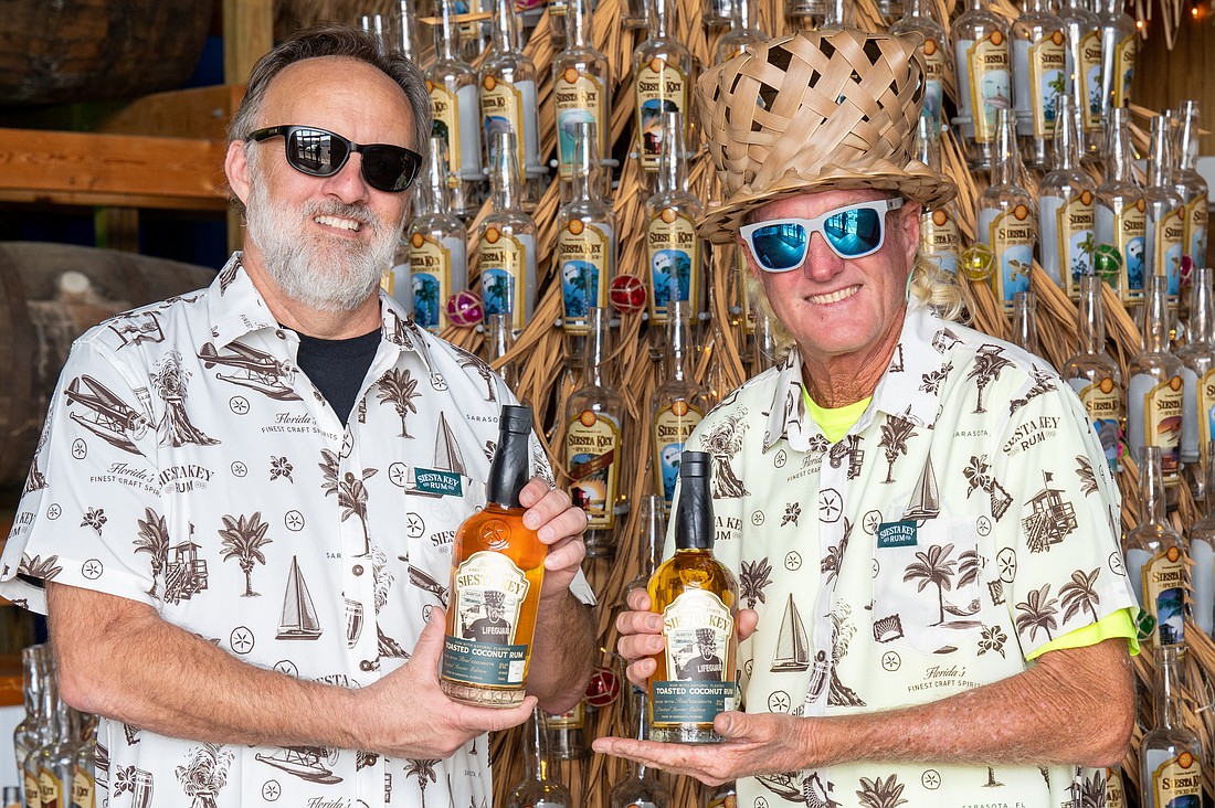 Troy Roberts and Scott Ruberg show off the new batch of limited-edition “Scooter of the Beach” rum.