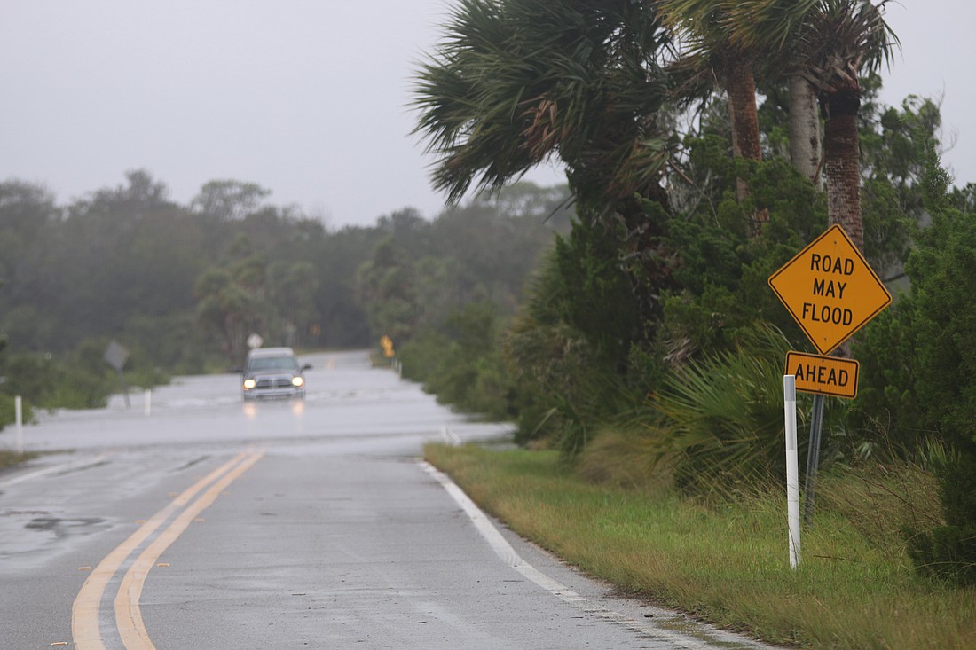 A vehicle drives through a flooded Walter Boardman Lane before Tropical Storm Nicole in 2022. File photo