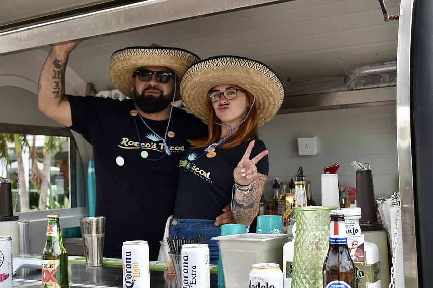 Servers Chris Reyes and Sarah Blanch man one of the drink carts outside.