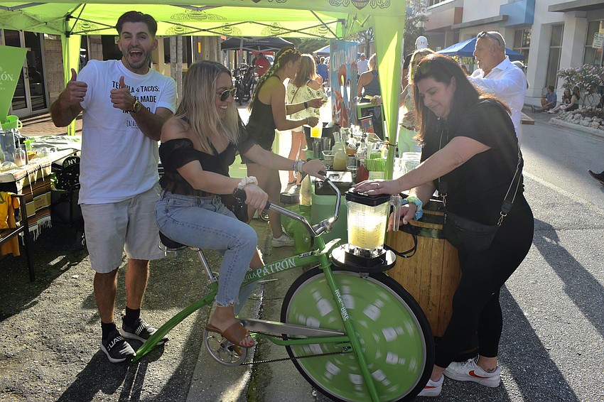 Allen Paquin applauds Sierra Paquin as she blends a lemonade cocktail for Jessica Brugick at the Circo event.