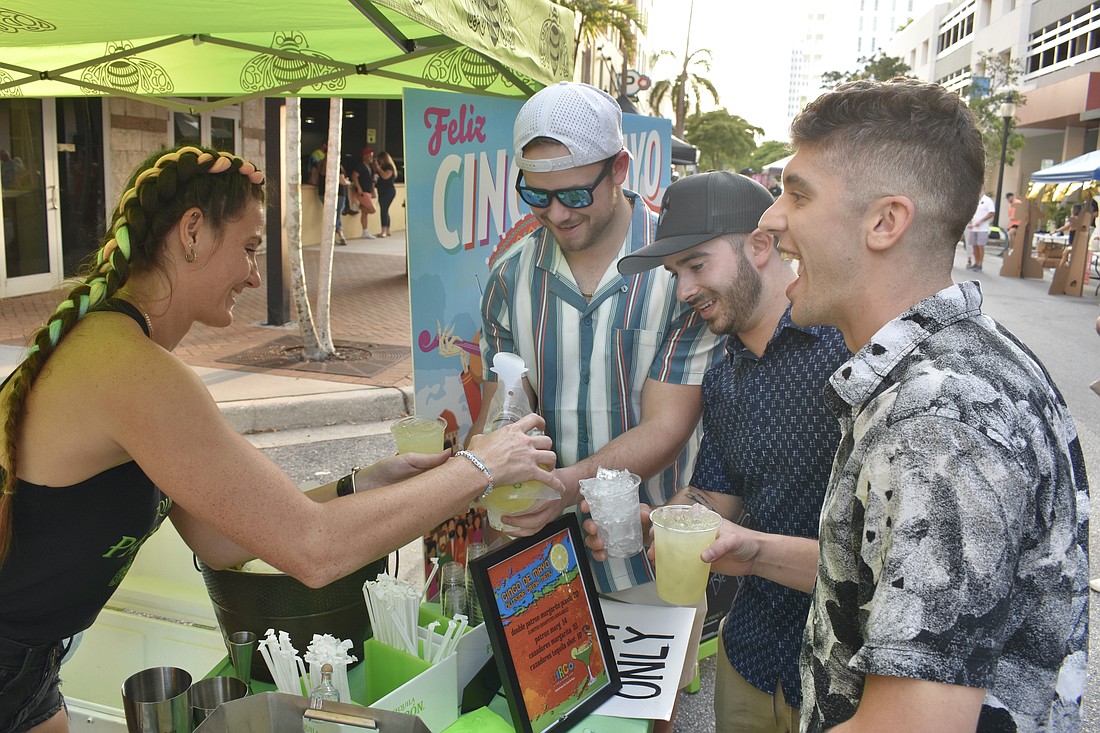 Julia King pours Patrón Tequila for Cedric Sullivan, Kyle Wilkinson, and Eduardo Stefonias on May 5, 2023, at Circo's street fest.