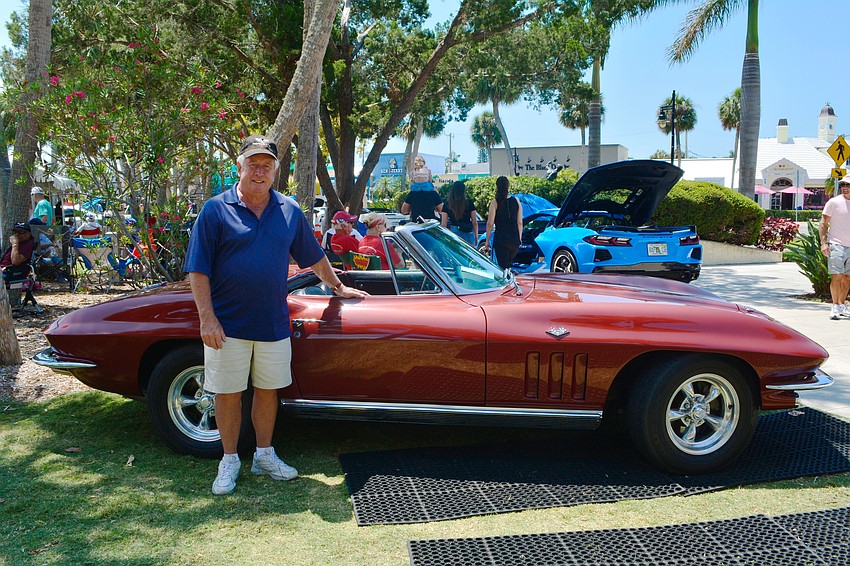 John Duggan stands next to his 1966 Maroon Corvette which took 10 years to restore.
