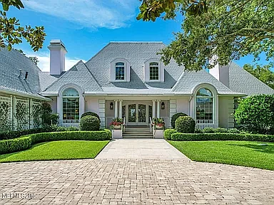 Lake and golf course frontage two-story home in Sawgrass Country Club features five bedrooms, five full and three half-bathrooms, office, game room, porches, balcony, deck, pavilion and pool.
