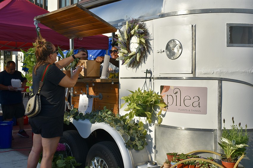 Sarasota resident Ellie Harris buys a couple gifts from Taylor Robison, owner of Pilea Plants & Things.