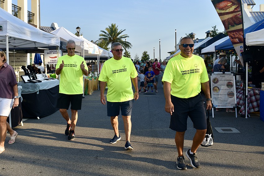 Lakewood Ranch residents Pat Geyer, John Caplan and Ed Agasi stroll through the market after playing cornhole.