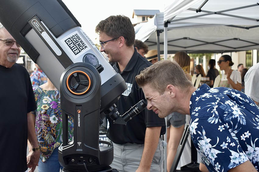 Palmetto resident Philip Winchester looks at Venus through the telescope brought by the Sidewalk Science Center.