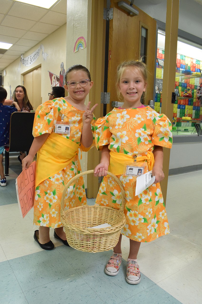 Kindergartners Eva Marino and Sagan Shinn welcome guests to the Banana Leaf Restaurant.