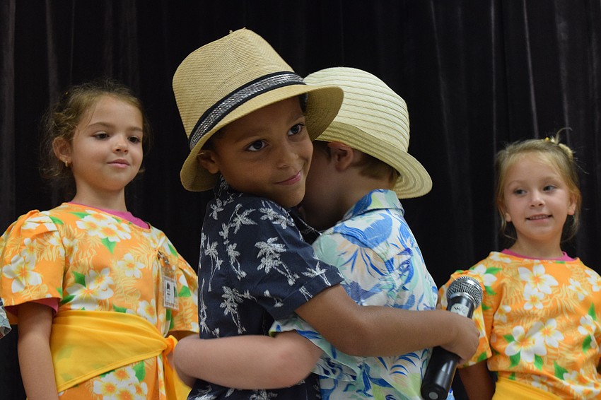 Kindergartner Cason Collier hugs his classmate Logan Johnson after they perform 