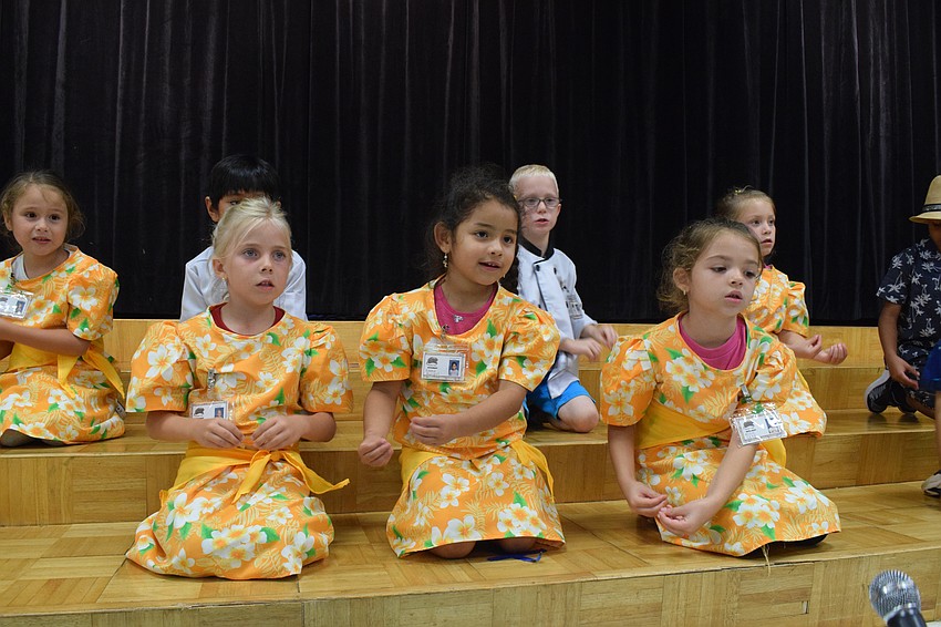 Kindergartners Allie Rose Withrow, Emma Carrillo and Alice Delia sing and dance in unison.