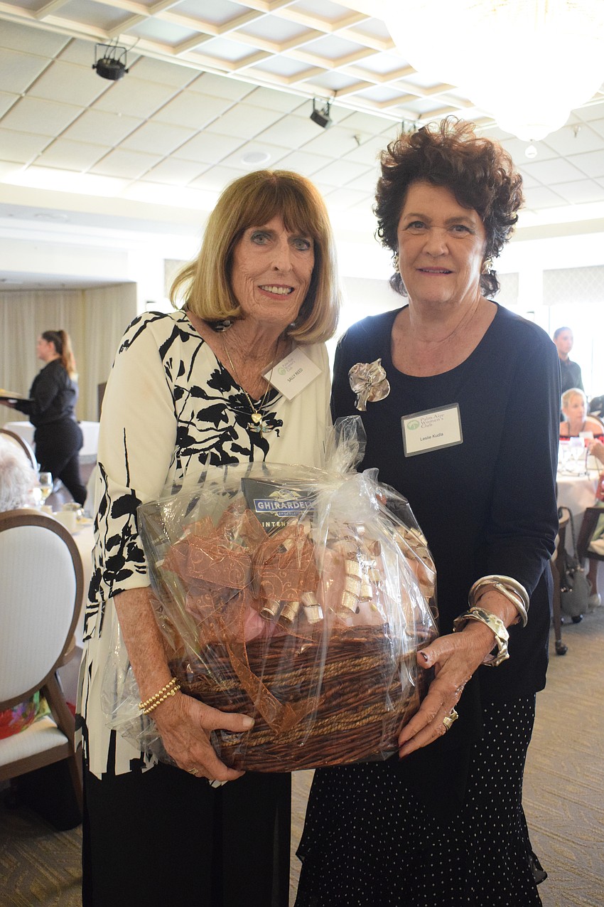 Palm Aire Women's Club's Sally Reed congratulates Leslie Kudia on winning a basket in a raffle.