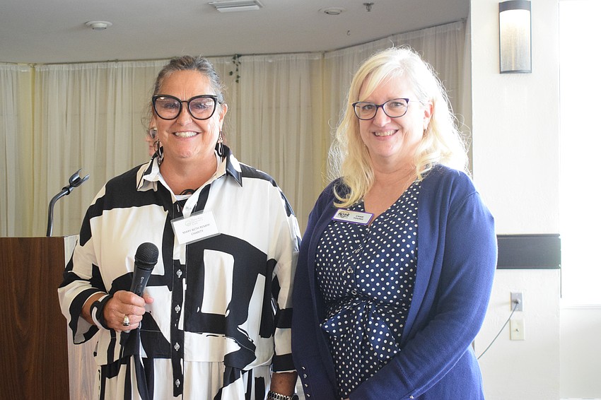 Mary Beth Rempp, a member of the Palm Aire Women's Club, presents Char Young, the CEO of Hope Family Services, with a grant. 