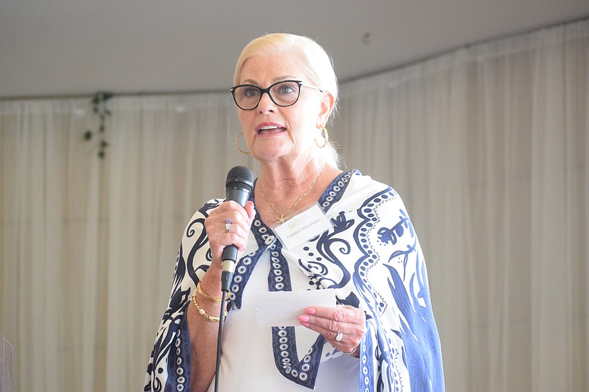 Candace Holloway, a member of the Palm Aire Women's Club, talks about the mission of Baby Basics of Sarasota County before presenting the nonprofit with a $1,000 grant.