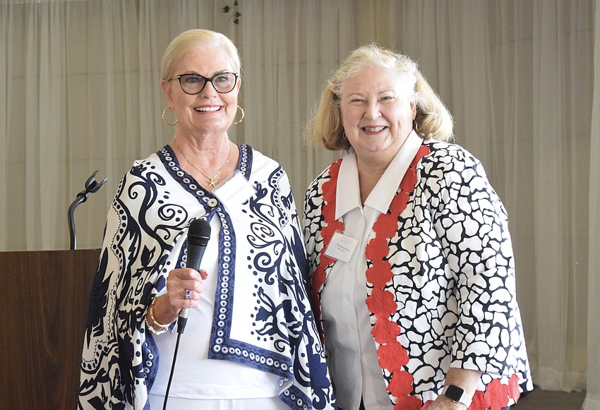 Candace Hollway, a member of the Palm Aire Women's Club, gives a grant to Barbara Price, the vice president of Baby Basics of Sarasota County. Price says the nonprofit is grateful for the years of support from the women's club.