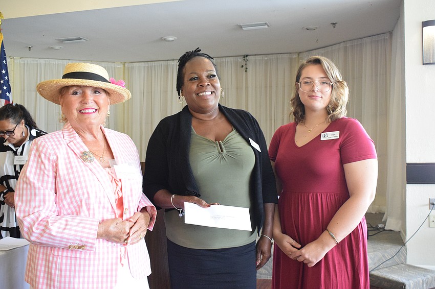 Palm Aire Women's Club's Carolann Garafola presents a grant to Second Chance's April Glasco, the founder and CEO, and Eryn McIntyre, the program director.