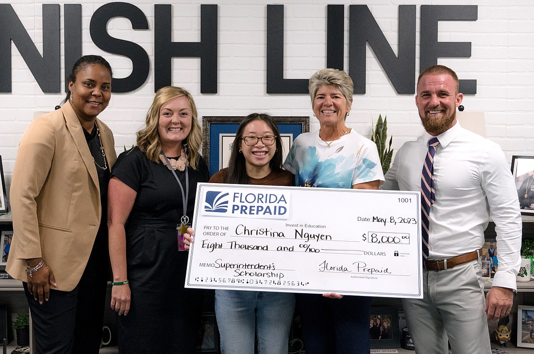 Christina Nguyen holds the oversized check with Assistant Superintendent Lashakia Moore, FPC Assistant Principal Stacia Collier, Superintendent Cathy Mittelstadt and FPC Principal Bobby Bossardet.