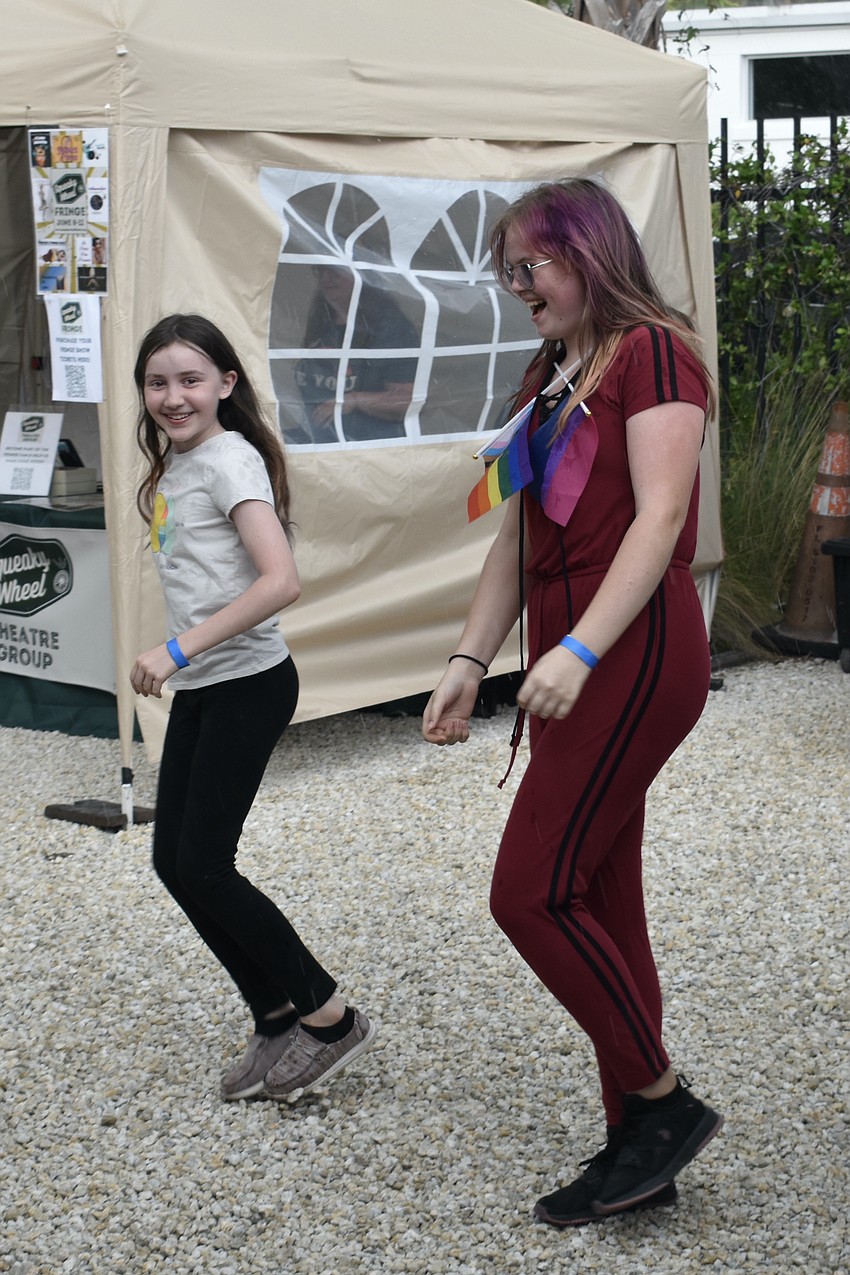 11-year-old Kali Wynn and 14-year-old Emily Maly keep the celebration going during a downpour, by dancing in the rain.