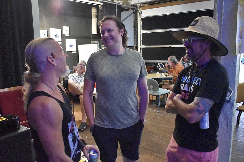 George Bikos, Miles Tweed, and David Curran chat with one another.