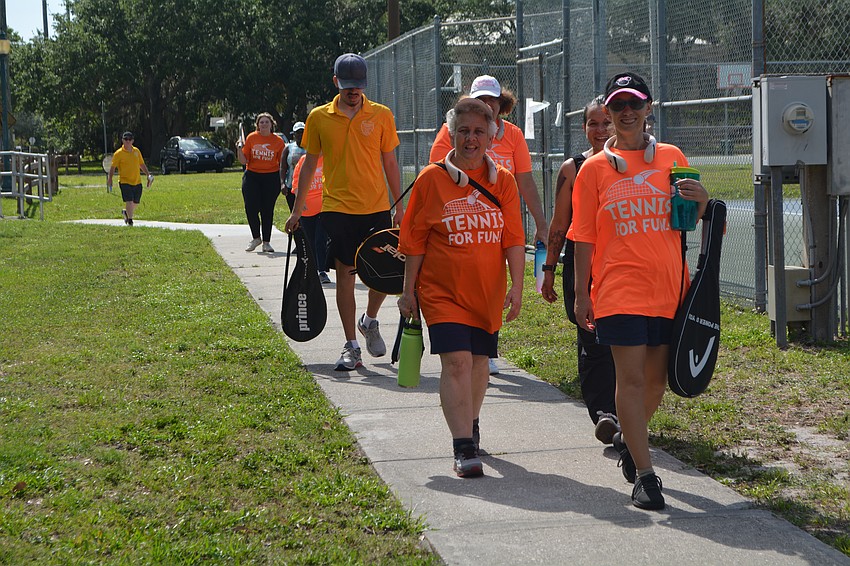 Tennis For Fun athletes start walking in to start playing tennis at Arlington Park.