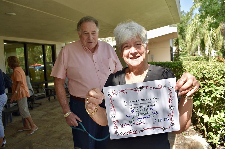 Gordon and Phyllis Loewengart present their certification of their dog Kyna's blessing from Temple Emanu-El.