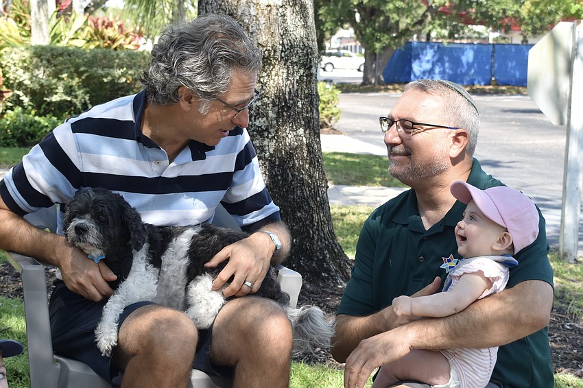Rabbi Brenner Glickman holds Goliath, while Rabbi Michael Shefrin holds his 8-month-old daughter Maya Shefrin.