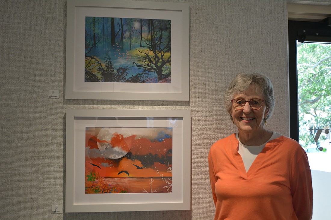 Frances Powers stands next to her digital paintings at All Angels By the Sea Episcopal Church.