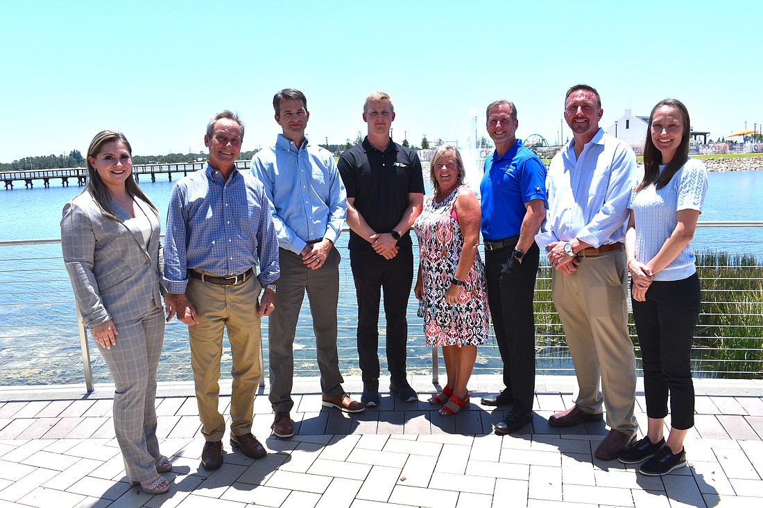 Svetlana Stelmach (Homes by Towne), Harry Fendt (Anchor Builders), Mike Woolery (Pulte Homes), Jack Cannon (John Cannon Homes), Adrienne Bookhamer (LWRCF), David Hunihan (Lee Wetherington Homes), Dominick Giallombardo (Stock Development) and Ashley Miller (AR Homes) gather at Waterside Place to announce the Builders Give Back program.