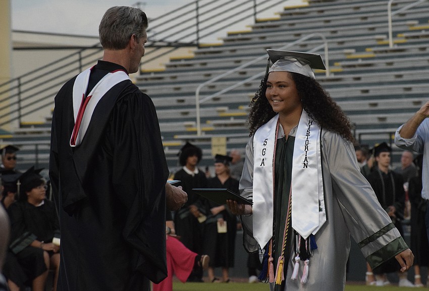 Lakewood Ranch High School Athletic Director Kent Ringquist hands Lilly Lynch her diploma.