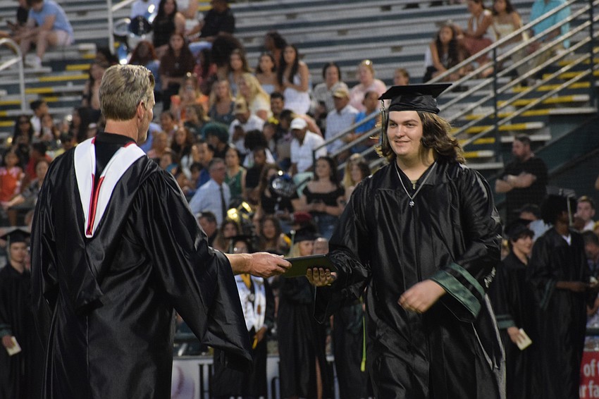 Lakewood Ranch High Athletic Director Kent Ringquist hands Sean O'Brien his diploma.