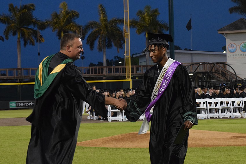 Lakewood Ranch High School Principal Dustin Dahlquist shakes hands with Jaithan Phillips, who was homecoming and prom king.