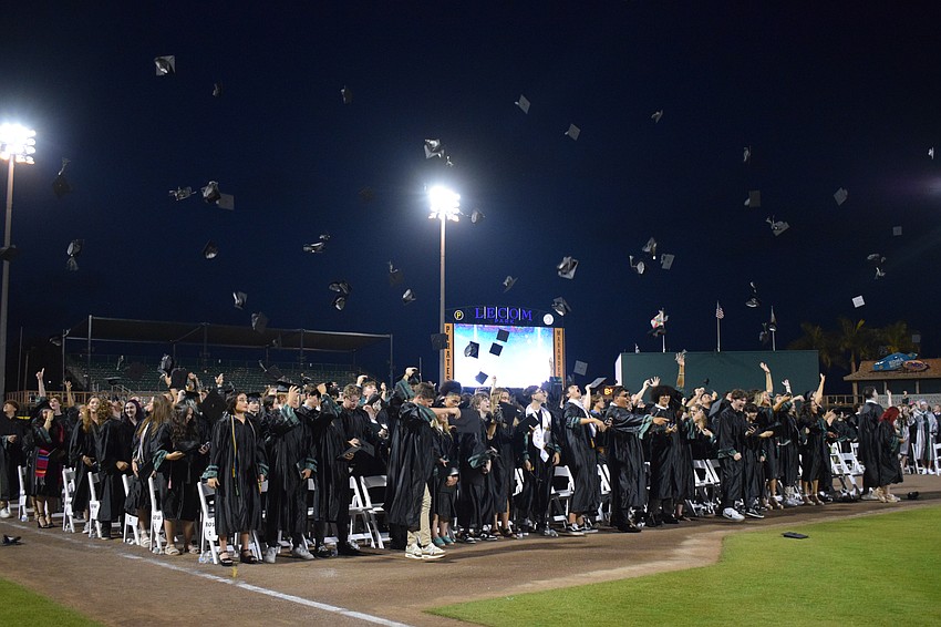 Lakewood Ranch High School graduates throw their caps into the air.