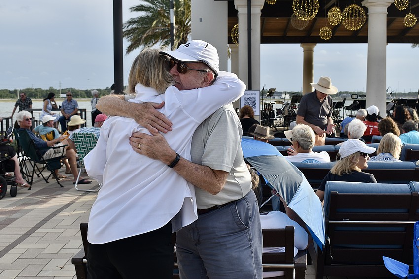 Nancy Dixon and Richard Talbot greet each other with a hug. The old friends originally met in Massachusetts and were attending the concert at Waterside Place.