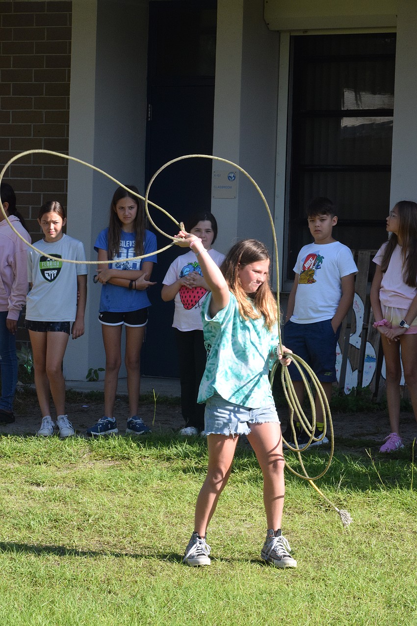 Kayleen Zieschang, a Gene Witt Elementary School fourth grader, uses a lasso to try to catch a fake cow.