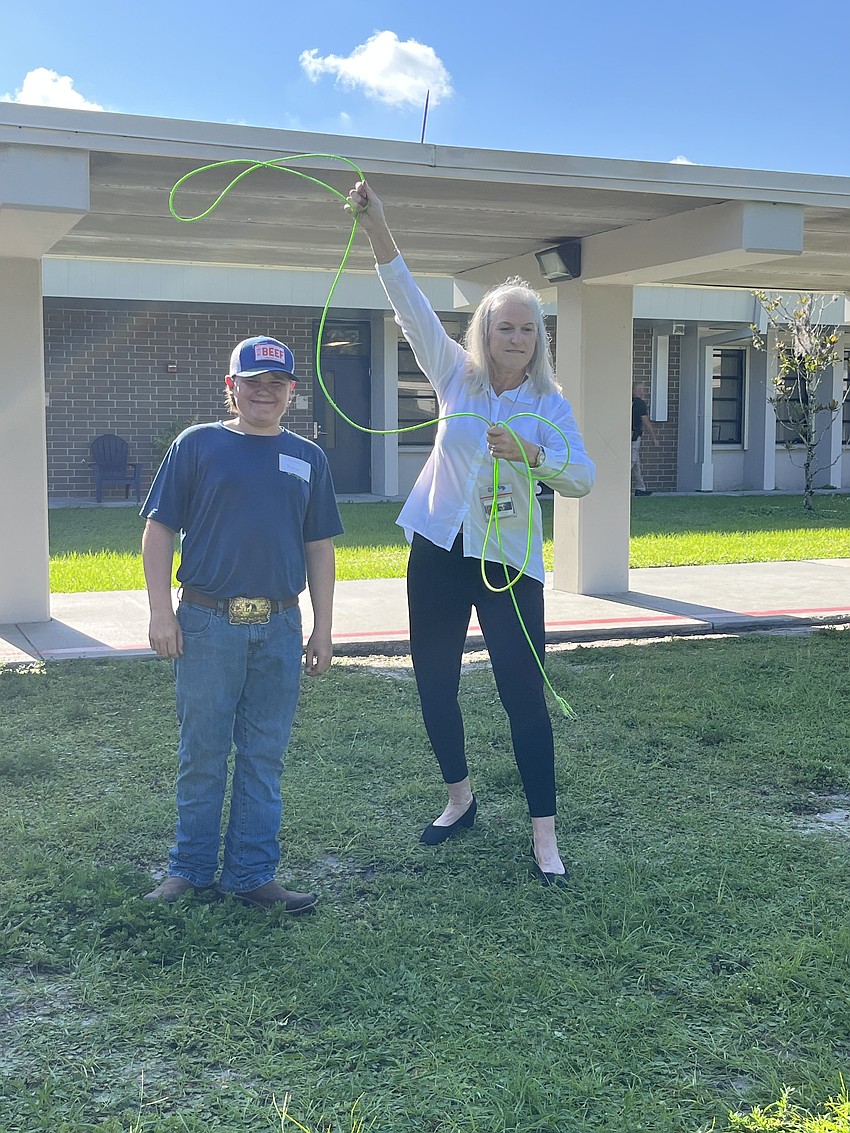Clayton Reagan with Reagan Ranch shows Gene Witt Elementary School Principal Connie Dixon how to lasso.