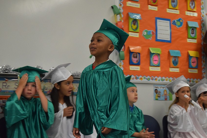 Mini Mustangs' Amir Phillips is all smiles as he walks to receive his diploma.