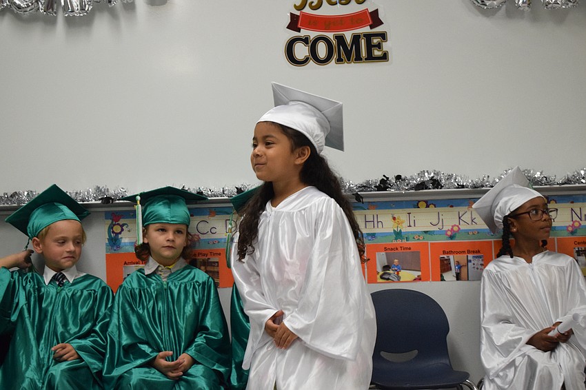 Mini Mustangs' Leanne Delcid excitedly walks to get her diploma.