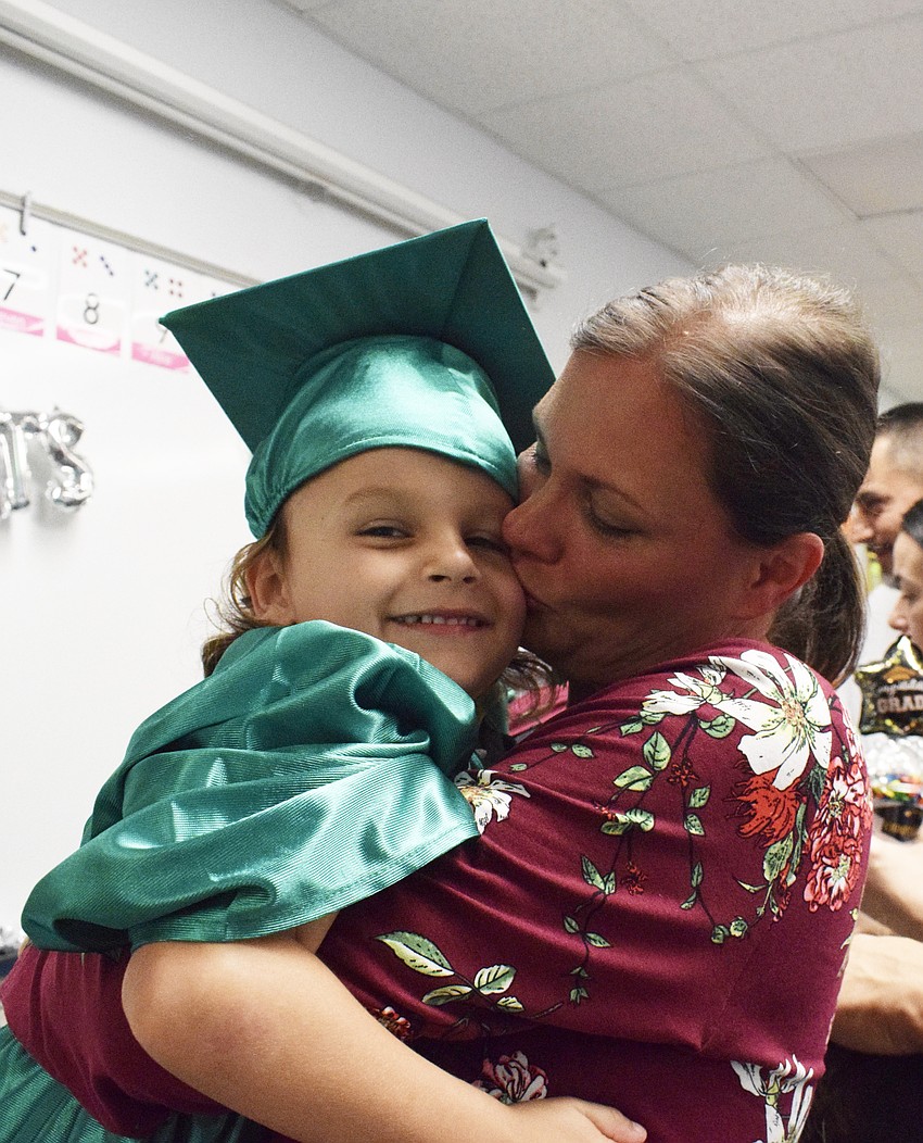Mini Mustangs' Michael Bess gets a kiss from Tiffany Montgomery.