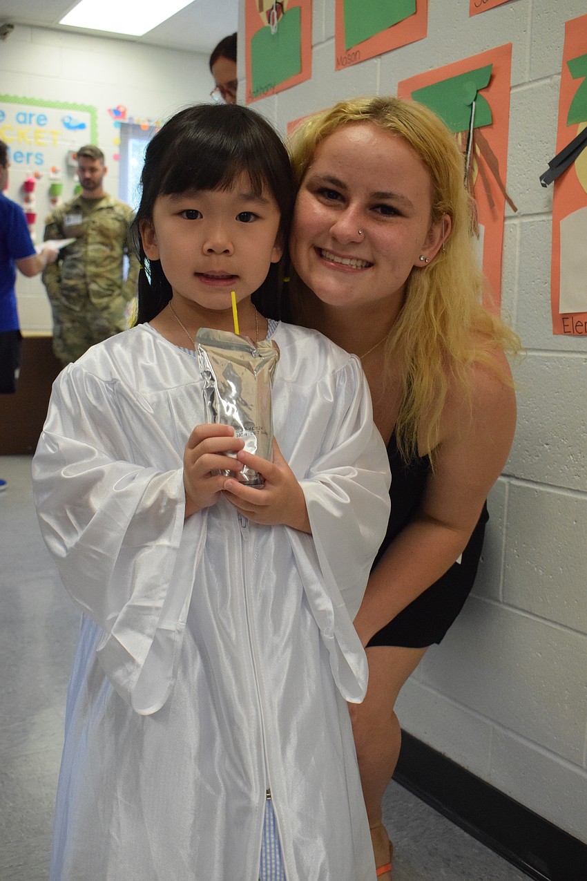 Mini Mustang's Alayna Nguyen and Lakewood Ranch High School senior Katie Wikner celebrate Nguyen's graduation from pre-K.