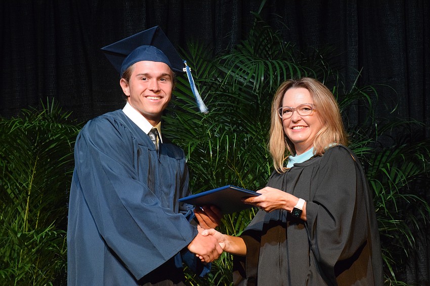 Out-of-Door Academy's Giovanni Giuliani accepts his diploma from Deb Otey, the head of school.