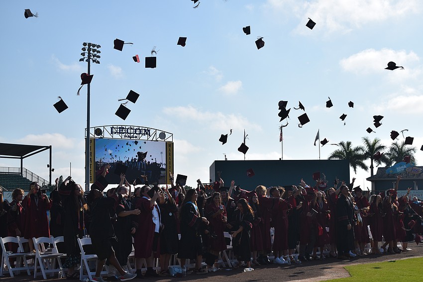 Braden River High School graduates throw their caps in the air.
