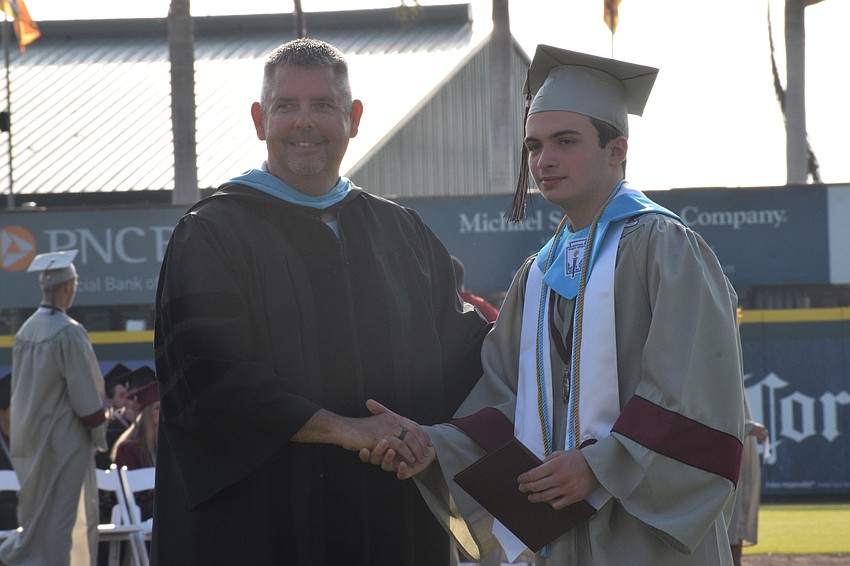 Braden River High School Principal Carl Auckerman congratulates Dylan Jackson.