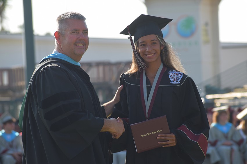 Braden River High School Principal Carl Auckerman shakes hands with Jusline Torres.