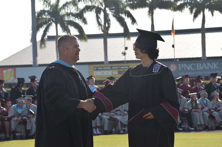 Braden River High School Principal Carl Auckerman congratulates Justin Millares.