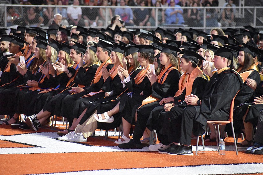 Graduates applaud during the ceremony.